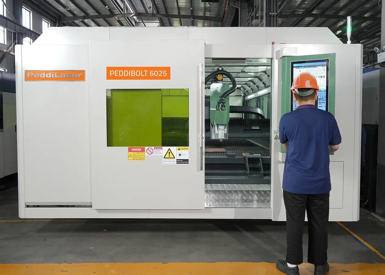 Man in front of a PeddiLaser machine control with the access door open